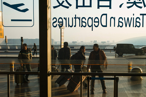 Tourists walk with their luggage at Beijing International Airport on Thursday (AFP photo)